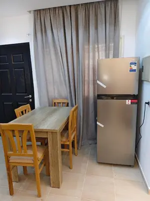 a kitchen with a wooden table and a refrigerator at منتجع نوبيا اكوا بيتش in Hurghada