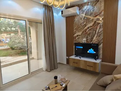 a living room with a tv and a large window at منتجع نوبيا اكوا بيتش in Hurghada
