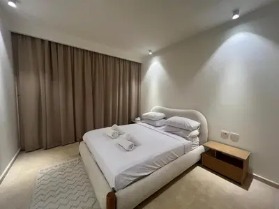 a bedroom with a bed with white sheets and pillows at Ancient Sands 2BR | Ground Floor, Pool Access in Hurghada