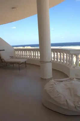 a room with a balcony with a view of the ocean at 36 Southwalk in Quseir