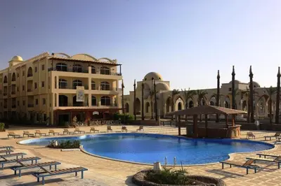 a large pool in a courtyard with benches and a building at Palm Beach Piazza Apart hotel Sahl Hasheesh Hurghada in Hurghada
