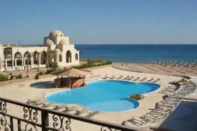 a resort with a swimming pool and chairs and the ocean at Palm Beach Piazza Apart hotel Sahl Hasheesh Hurghada in Hurghada