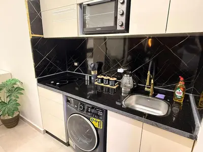a kitchen with a sink and a washing machine at Tiba golden resort in Hurghada