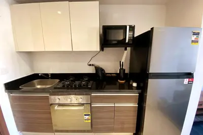 a small kitchen with a refrigerator and a sink at Contemporary Condo Studio in G-Cribs in El Gouna