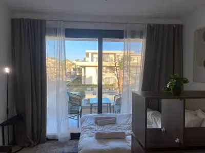 a bedroom with a bed and a large window at Contemporary Condo Studio in G-Cribs in El Gouna