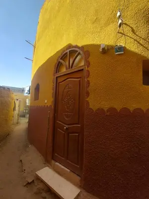 a brown door in a yellow building with a door at moon guest house in Jazīrat Aswān
