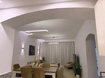 a dining room and living room with a table and chairs at Luxury Apartment In Azzurra Sahl Hashish 6G101 in Hurghada