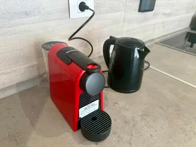 a red and black toaster next to a cup at Bright 1BR Apt - Free Beach And Pool In Mangroovy ElGouna in Hurghada