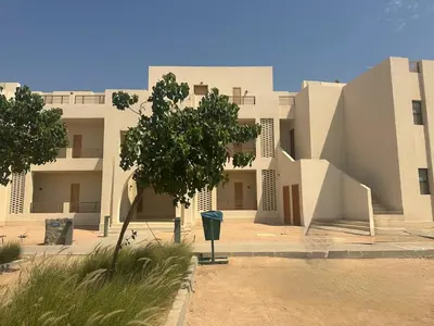 a building with a tree in front of it at Colorful 1BR Apt-Free Pool & Lagoon Access In ElGouna in Hurghada