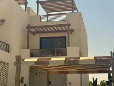 a large house with a balcony with a deck at Colorful 1BR Apt-Free Pool & Lagoon Access In ElGouna in Hurghada