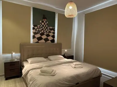 a bedroom with a bed with two towels on it at Colorful 1BR Apt-Free Pool & Lagoon Access In ElGouna in Hurghada