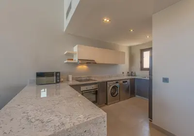a kitchen with a counter top with a washer and dryer at Ancient Sands 3BR Twin Villa with a Private Patio Heated Swimming Pool & Lagoon Access in Hurghada