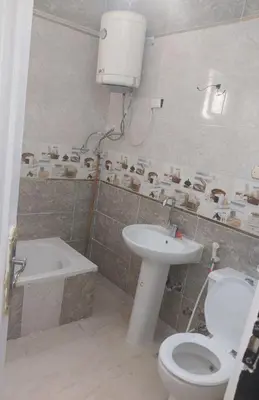 a bathroom with a toilet and a sink and a tub at شقة سكنية كبيرة in Aswan