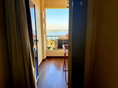 a room with a view of the ocean from a balcony at Sun Palace House in Luxor