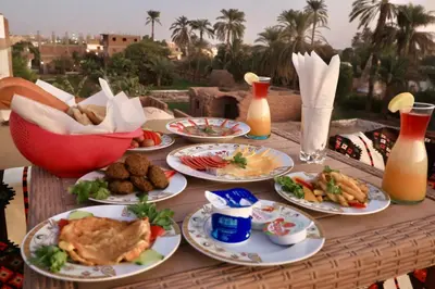 a table with plates of food and drinks on it at White Gorf Hotel in Luxor