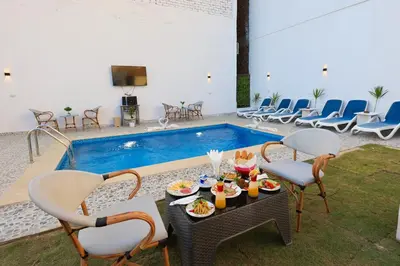 a patio with a table and chairs and a pool at White Gorf Hotel in Luxor