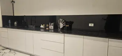 a kitchen with white cabinets and a black counter top at ROOF TOP 12 Seaview in Hurghada
