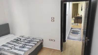 a bedroom with a bed and a door leading to a hallway at Nice flat in region Intercontinental in Hurghada