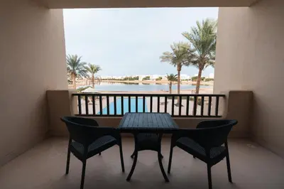 a table and chairs on a balcony with a view of the beach at Joubal 2BR Lagoon View Residence in Hurghada