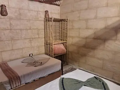 a room with two beds and a table with a bow tie at Labib Guest house in Aswan