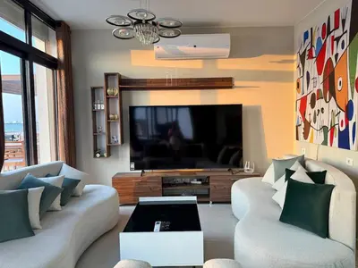 a living room with two couches and a flat screen tv at Sunny 4BR Villa Plus Nanny With Private Heated Pool And Jacuzzi In ElGouna in Hurghada