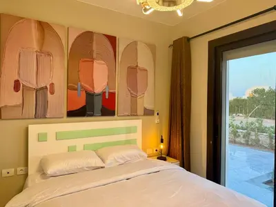 a bedroom with a bed and a painting of surfboards at Sunny 4BR Villa Plus Nanny With Private Heated Pool And Jacuzzi In ElGouna in Hurghada