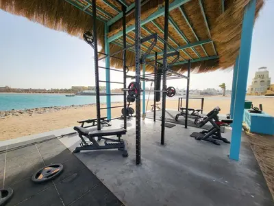 a gym on the beach with benches and machines at Mangroovy -2BR GF Hacienda House Pool & Beach access in Hurghada