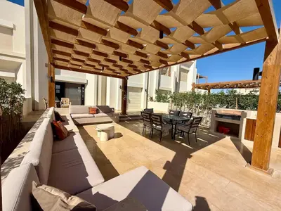 a patio with a couch and a table and chairs at Premium 3BR Plus Nanny Villa -Free Pool And Lagoon Access In ElGouna in Hurghada