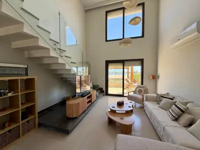 a living room with a couch and a staircase at Premium 3BR Plus Nanny Villa -Free Pool And Lagoon Access In ElGouna in Hurghada