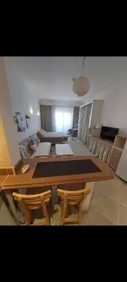 a living room with a table and some chairs at 1 Bedroom in Port Ghalib