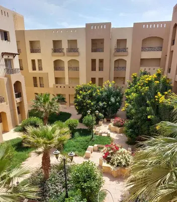 an exterior view of a building with trees and plants at 1 Bedroom in Port Ghalib