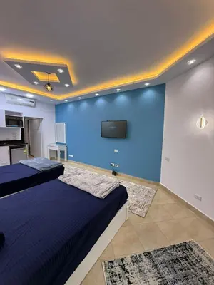a bedroom with two beds and a flat screen tv at Diamond resort Hurghada 7 in Hurghada