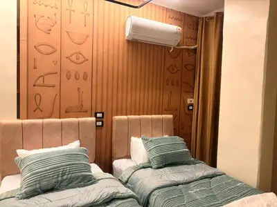 a room with two beds and a wall with a heater at Woori Duri \ud658\ub300\ub97c \uc704\ud574 in Aswan