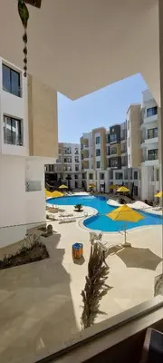 a large swimming pool with umbrellas in a building at Relax near the sea, one bedroom flat in Hurghada