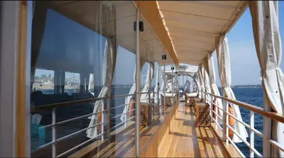 a balcony on a boat with a view of the water at Soul of the nile Dahabyia in Al Baghdādī
