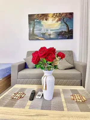 a vase with red roses on a table in a living room at G Grips Grand 4 in El Gouna
