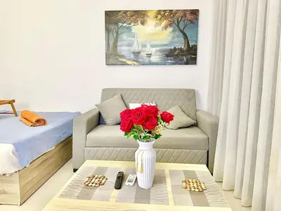 a living room with a couch and a vase with red roses at El Gouna in Hurghada