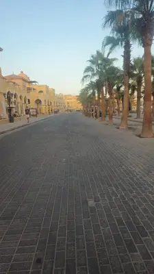 an empty street with palm trees and buildings at Paradise Studio with pool in Hurghada