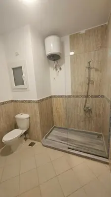 a bathroom with a shower with a toilet and a glass shower stall at Paradise Studio with pool in Hurghada