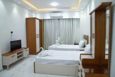 a hotel room with two beds and a television at Juliana beach luxury family suites in Hurghada