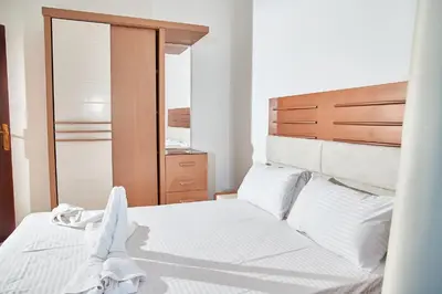 a bedroom with a white bed with a wooden headboard at Juliana beach luxury family suites in Hurghada