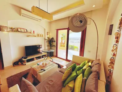 a living room with a couch and a tv at El Gouna - Sabina - Lagoon Chalet - 2 bedrooms - Ground Floor in El Gouna