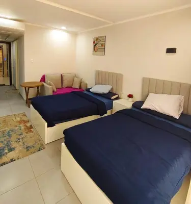 a bedroom with two beds and a table at Scandic resort near diving center Colona Divers Hotel Room in Hurghada