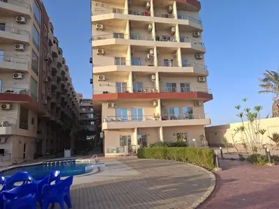 an apartment building with a swimming pool in front of it at Casblanka beach in Hurghada