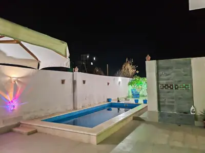a swimming pool at night with a tent at Villa malaika with Private swimming pool in Luxor