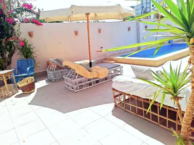 a patio with chairs and an umbrella and a pool at Villa malaika with Private swimming pool in Luxor