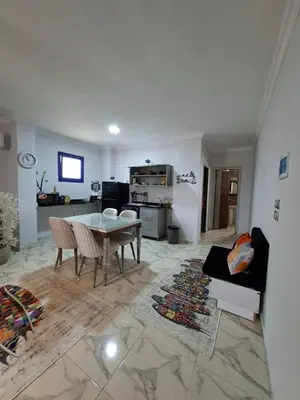 a living room with a table and a kitchen at Apartment for Rent Hurghada, Oasis Marina Resort in Hurghada