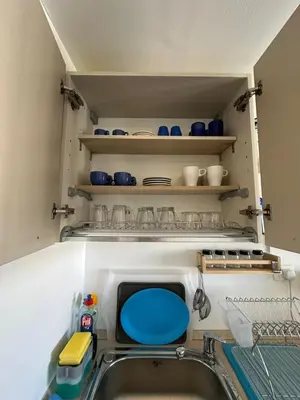 a kitchen with a sink and shelves with dishes at Refined Two-Bedroom with Pool View Gcribs ElGouna in El Gouna