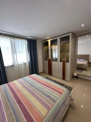 a bedroom with a large bed with a colorful rug at Refined Two-Bedroom with Pool View Gcribs ElGouna in El Gouna