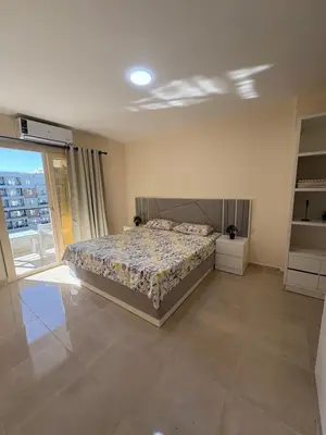 a bedroom with a bed and a large window at TIBA GOLDEN Hurgada in Hurghada